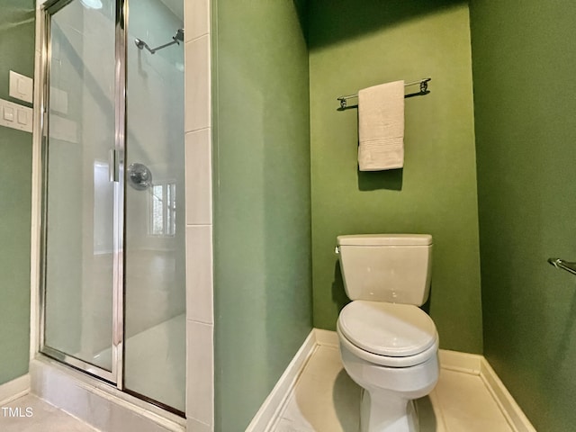 bathroom featuring toilet, tile patterned flooring, and a shower with shower door