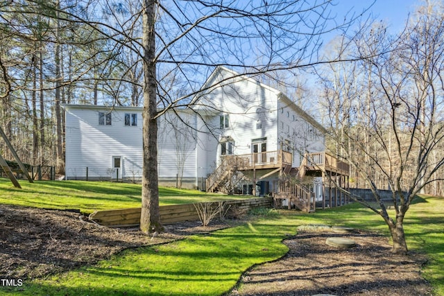 back of property featuring a lawn and a wooden deck