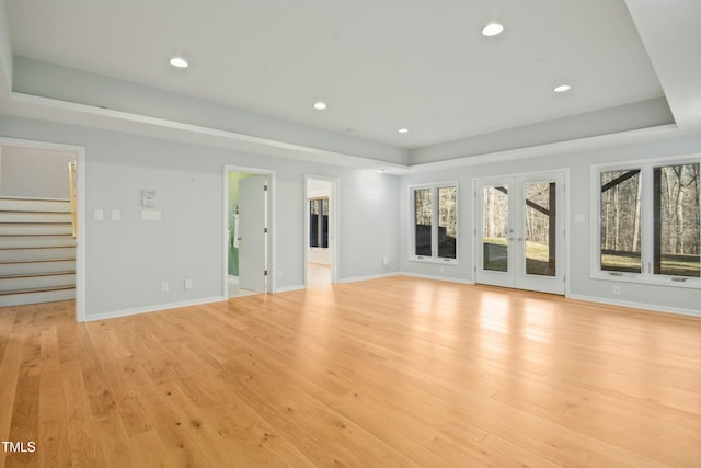 unfurnished living room featuring light hardwood / wood-style floors and french doors