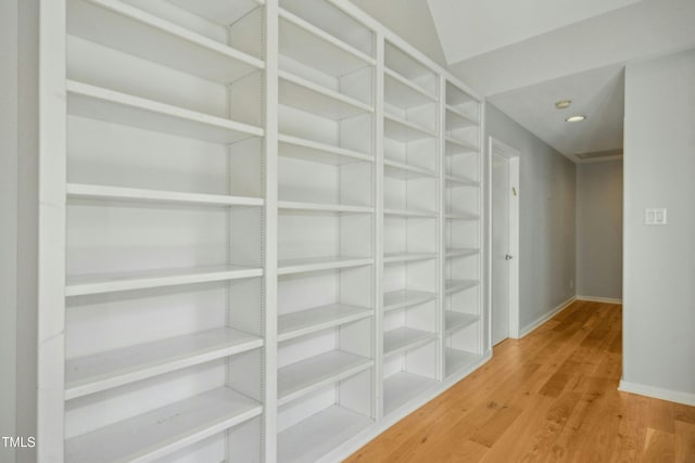 corridor with hardwood / wood-style flooring