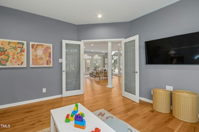 game room with hardwood / wood-style flooring and french doors