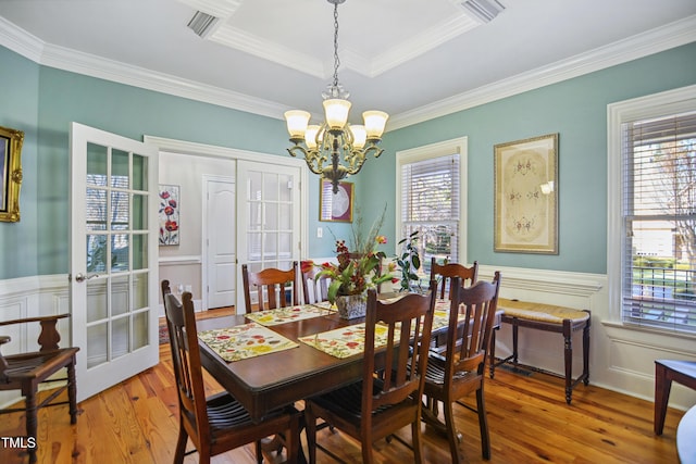 dining area featuring a wainscoted wall, plenty of natural light, and wood finished floors