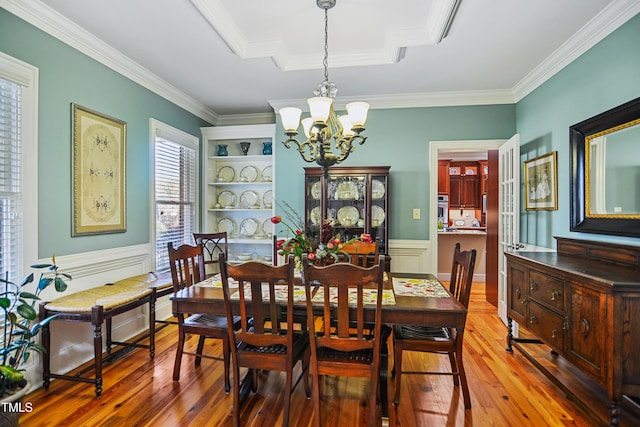 dining room featuring an inviting chandelier, light wood-style flooring, and crown molding