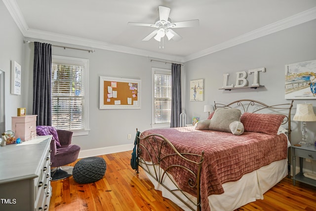 bedroom with light wood-type flooring, a ceiling fan, baseboards, and crown molding