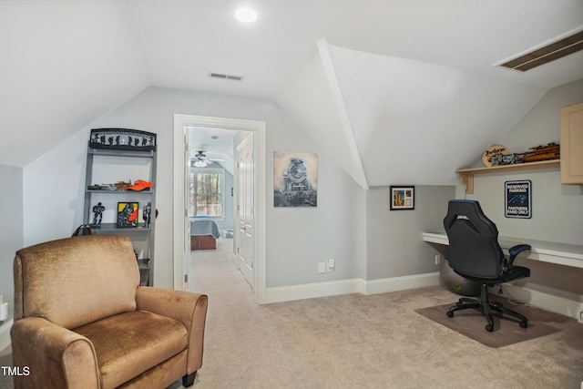 office space with light colored carpet, visible vents, vaulted ceiling, and baseboards