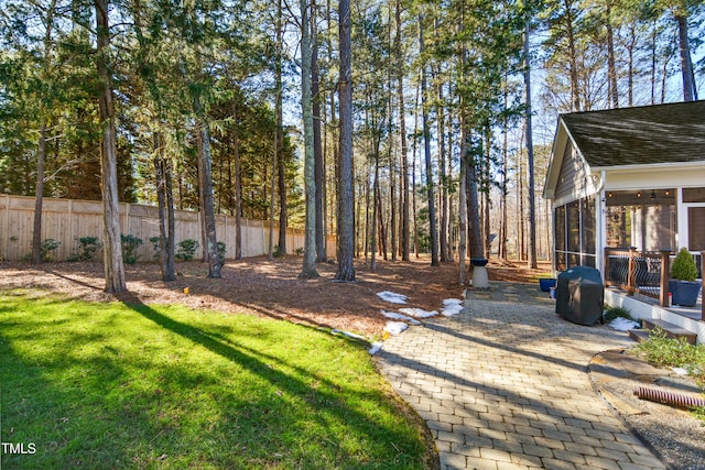 view of yard featuring fence and a sunroom