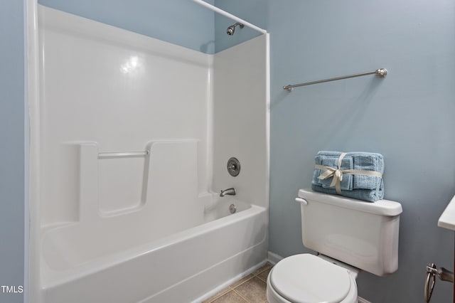 bathroom featuring tile patterned flooring, toilet, and tub / shower combination