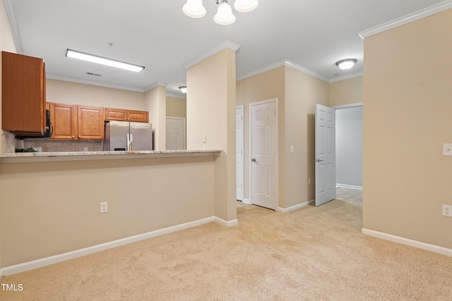 kitchen with light carpet, stainless steel fridge, kitchen peninsula, light stone countertops, and ornamental molding