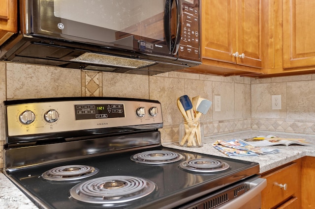 kitchen with decorative backsplash, stainless steel electric range oven, and light stone counters