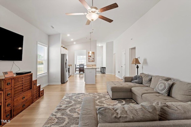 living room featuring ceiling fan, high vaulted ceiling, light wood finished floors, and recessed lighting