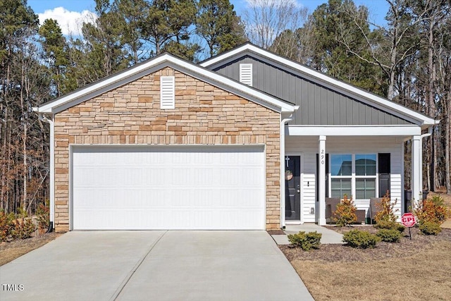 view of front facade featuring driveway, stone siding, and an attached garage