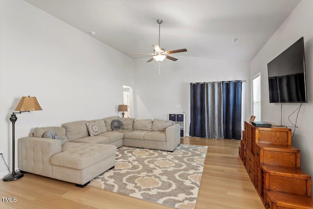 living area featuring lofted ceiling, ceiling fan, visible vents, and light wood-style flooring