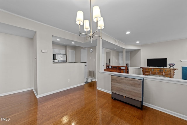 kitchen featuring hardwood / wood-style flooring, stainless steel refrigerator, decorative light fixtures, and a notable chandelier