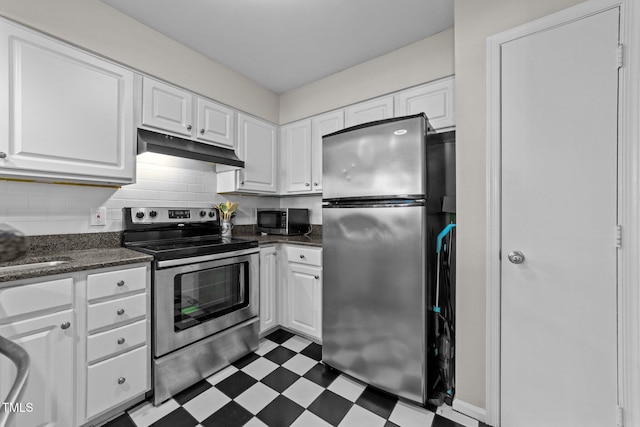 kitchen with stainless steel appliances, tasteful backsplash, white cabinets, and dark stone counters