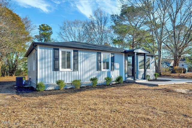 view of front of property featuring a front yard and cooling unit