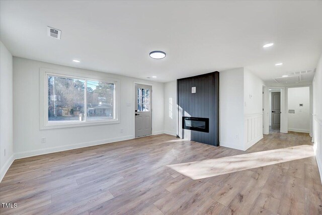 foyer entrance with light wood-type flooring and a fireplace