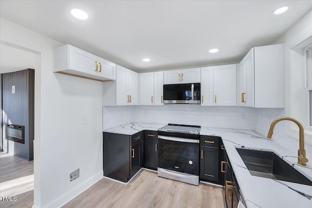 kitchen featuring stainless steel appliances, white cabinets, tasteful backsplash, and sink