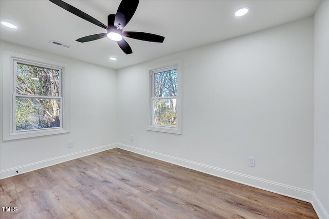 empty room with ceiling fan and light hardwood / wood-style flooring