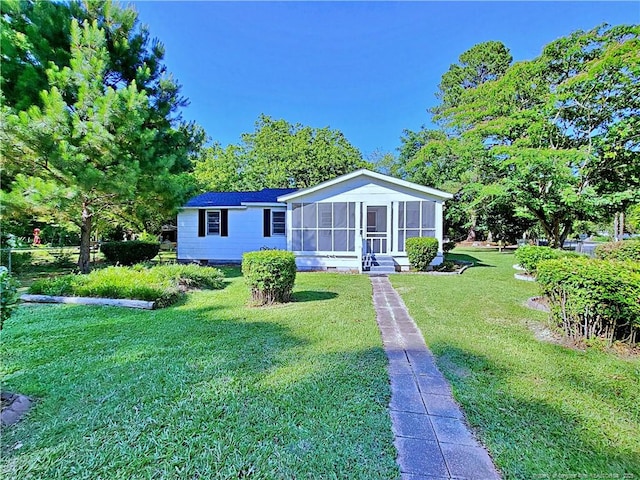 manufactured / mobile home with a sunroom and a front yard