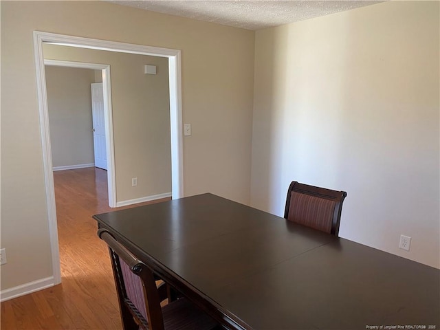 unfurnished office with light hardwood / wood-style floors and a textured ceiling