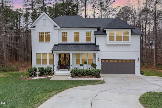 modern farmhouse featuring a garage and a yard