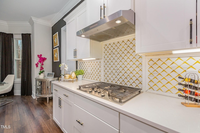 kitchen with exhaust hood, stainless steel gas stovetop, decorative backsplash, dark hardwood / wood-style floors, and crown molding