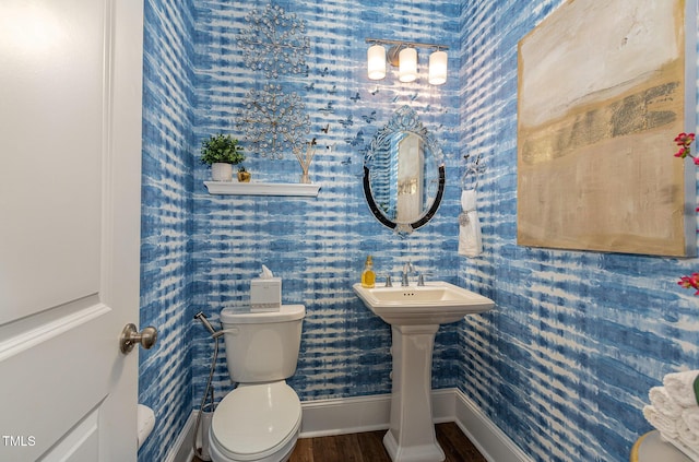 bathroom with toilet, wood-type flooring, and sink