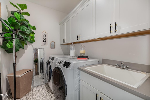 clothes washing area with cabinets, light tile patterned floors, independent washer and dryer, and sink