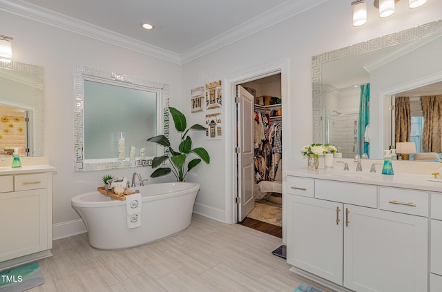 bathroom with a tub, vanity, and ornamental molding