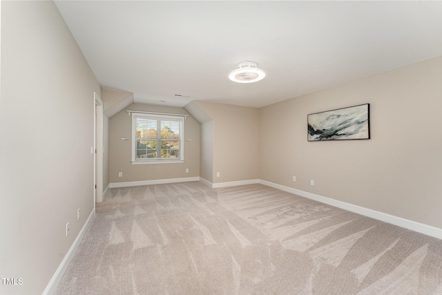 bonus room with light carpet and vaulted ceiling