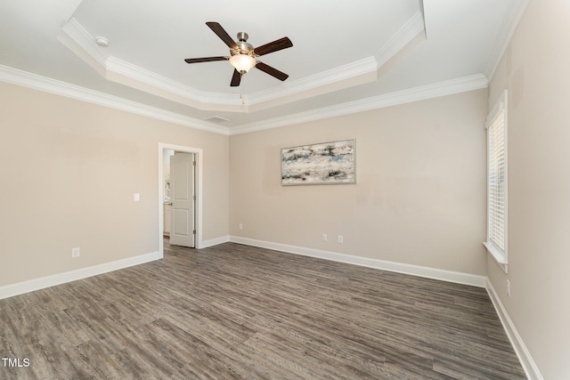 unfurnished room featuring ornamental molding, ceiling fan, a tray ceiling, and dark hardwood / wood-style flooring