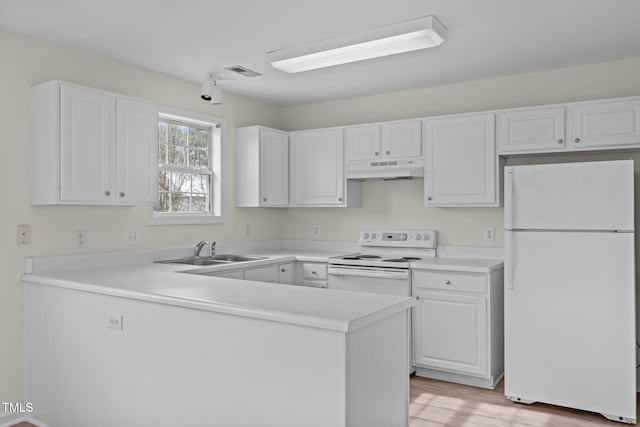 kitchen with white cabinetry, sink, kitchen peninsula, white appliances, and light hardwood / wood-style flooring