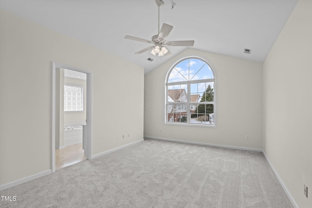 unfurnished bedroom with light carpet, ceiling fan, vaulted ceiling, and ensuite bath