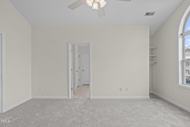 spare room featuring light colored carpet and ceiling fan