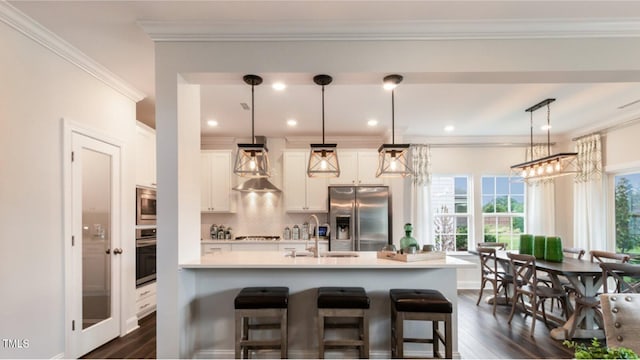 kitchen featuring pendant lighting, white cabinets, sink, and appliances with stainless steel finishes