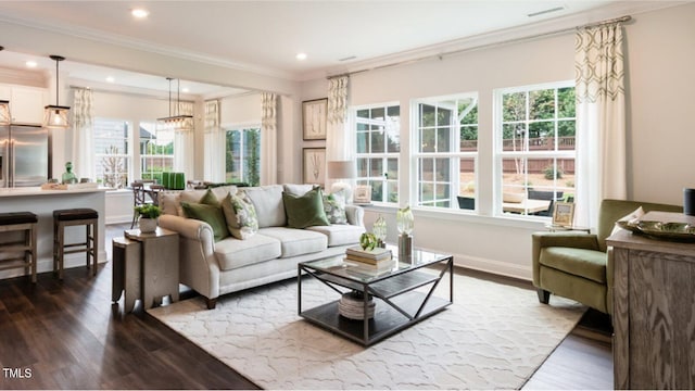 living room featuring dark hardwood / wood-style floors, crown molding, and a healthy amount of sunlight