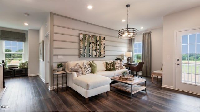 living room featuring an inviting chandelier and dark wood-type flooring