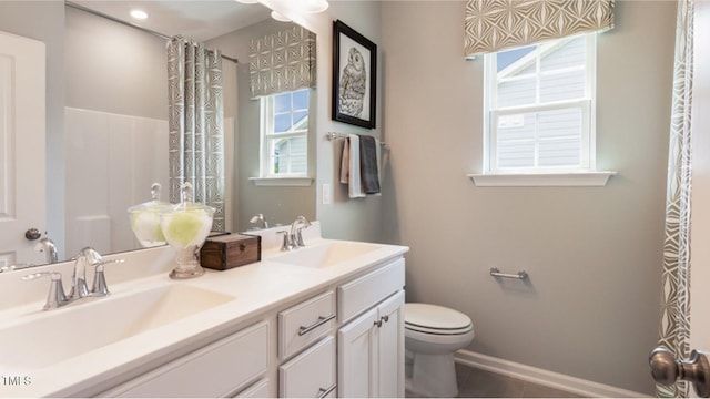 bathroom featuring vanity, a healthy amount of sunlight, and toilet