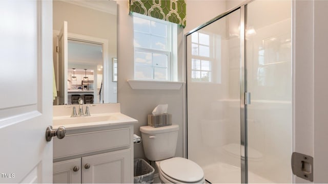 bathroom with toilet, vanity, ornamental molding, and walk in shower