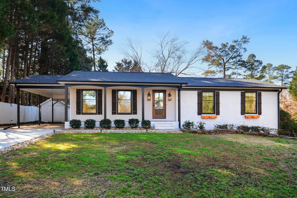 ranch-style house with a carport, a porch, and a front lawn