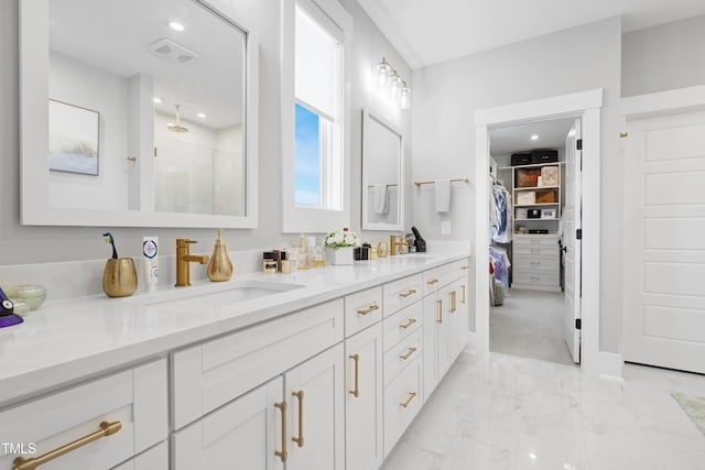 bathroom featuring a shower with shower door and vanity