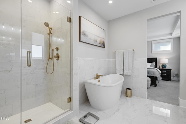 bathroom featuring independent shower and bath and tile walls