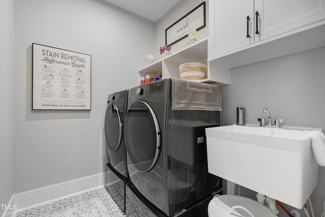 laundry room with cabinets, washer and clothes dryer, and sink