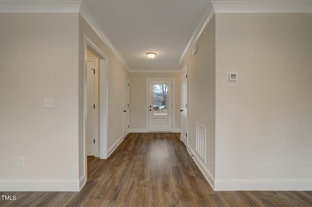 entryway with ornamental molding and wood-type flooring