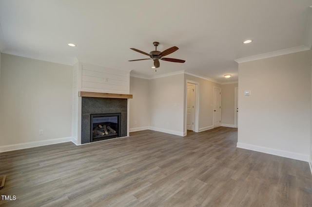 unfurnished living room featuring hardwood / wood-style flooring, crown molding, and ceiling fan