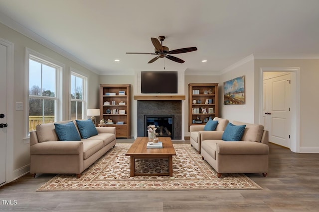 living room featuring ceiling fan, wood-type flooring, and ornamental molding