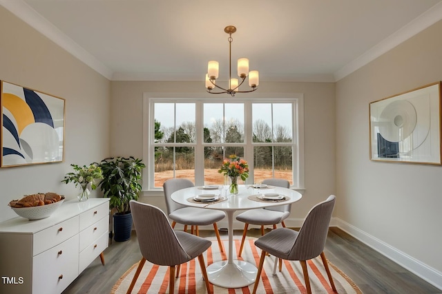 dining area with dark hardwood / wood-style flooring, ornamental molding, and a chandelier