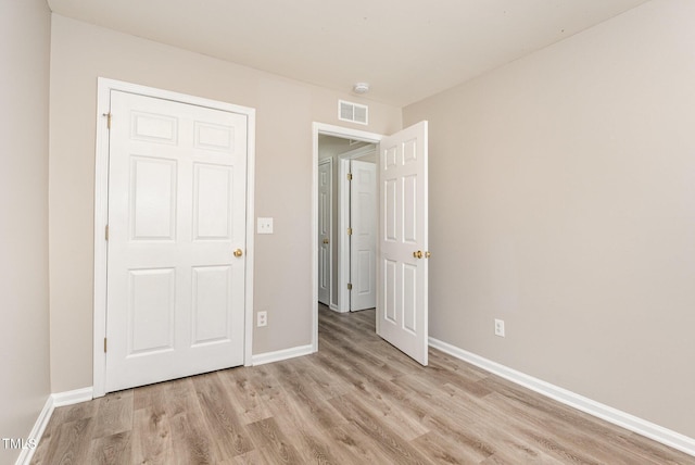 unfurnished bedroom with light wood-type flooring and a closet