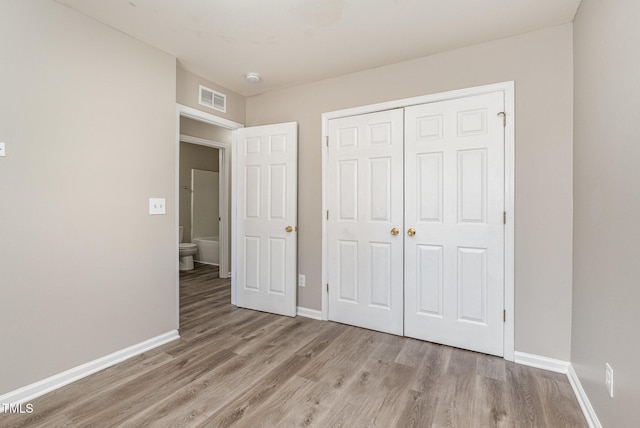 unfurnished bedroom with a closet and light wood-type flooring