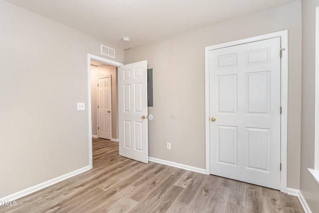 unfurnished bedroom with a closet and light wood-type flooring